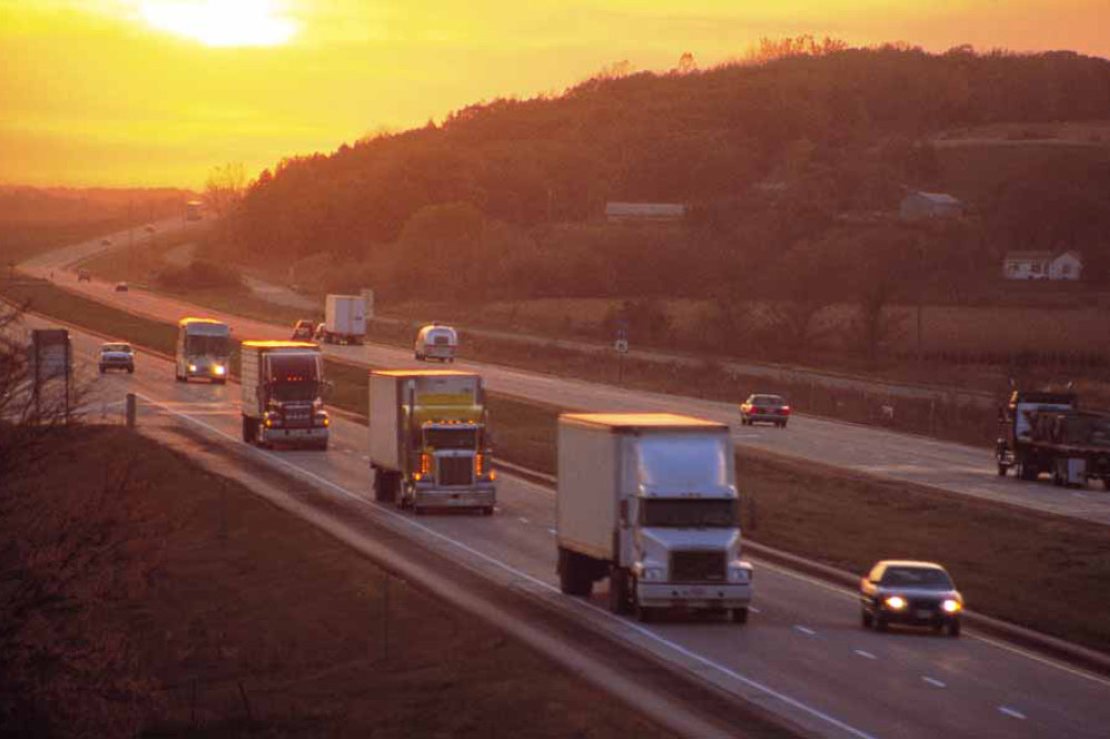 Trucks on highway at sunset