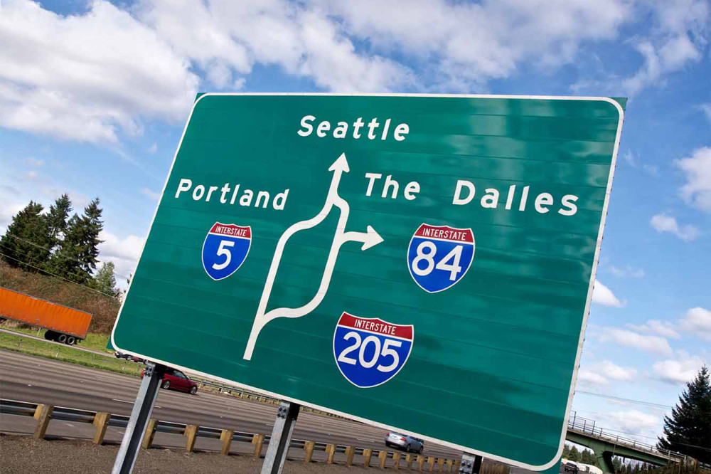 Highway sign for Interstates 5, 84, and 205 pointing to Portland, Seattle and The Dalles